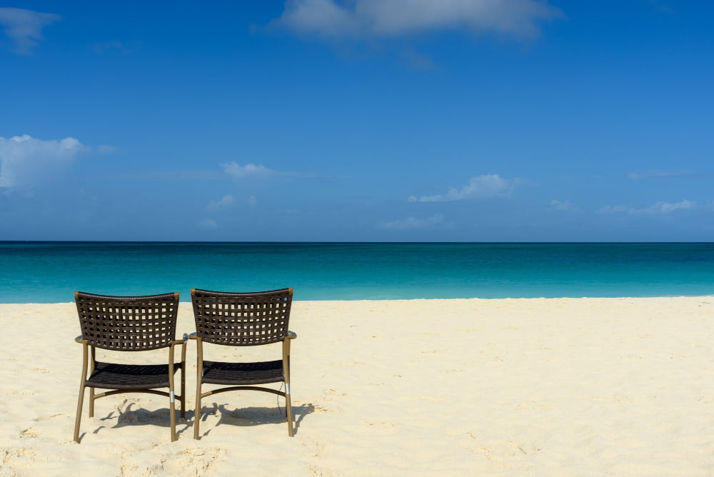 mesmerizing view of the beach and sea with two chairs on the shore