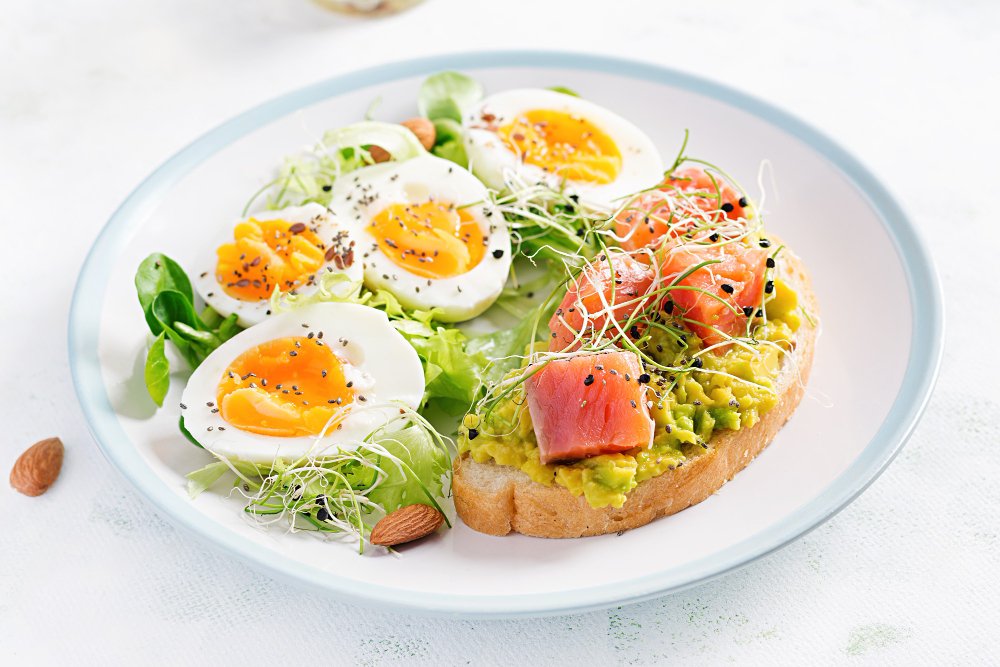 breakfast healthy open sandwich toast with avocado salmon boiled eggs herbs chia seeds white plate with copy space healthy protein food